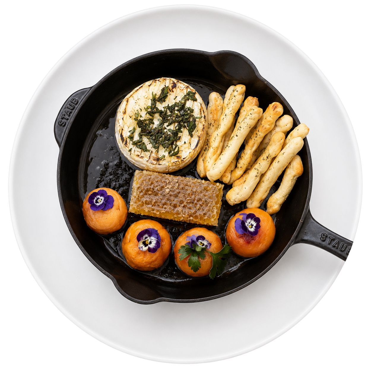A cast-iron skillet featuring warm baked brie, honeycomb, and breadsticks, highlighting the welcoming hospitality at our South Portland event space.