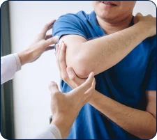 Physician examining a patient's elbow during an orthobiologic evaluation