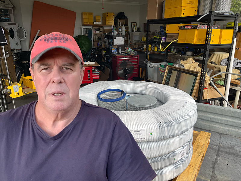 Rob Whittle in his Spillrite workshop with industrial vacuum hose and filters
