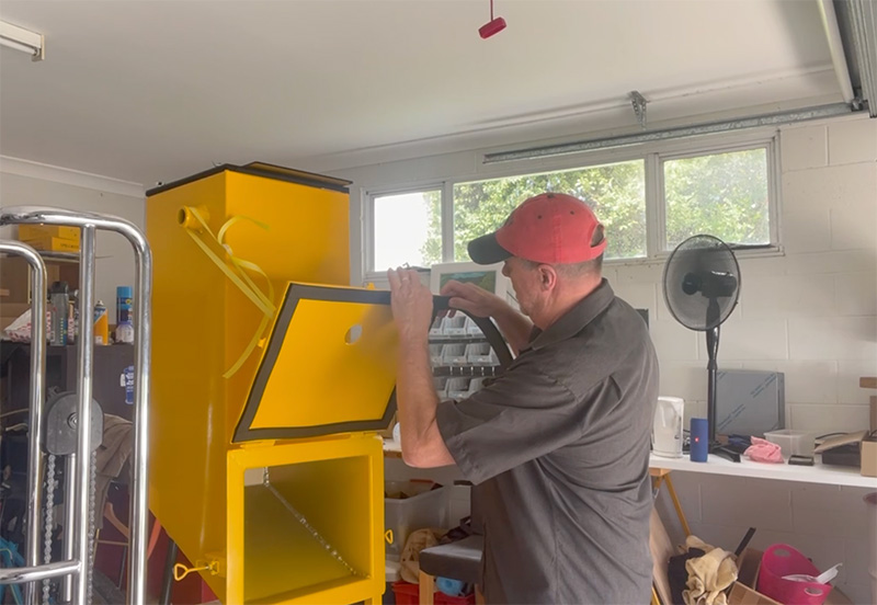 Rob Whittle working on an industrial vacuum in his garage workshop