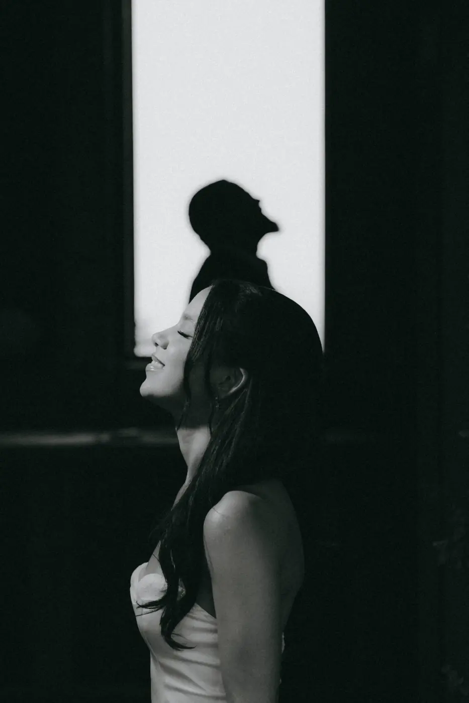 Perfil de la novia sonriendo con la sombra del novio detr&aacute;s