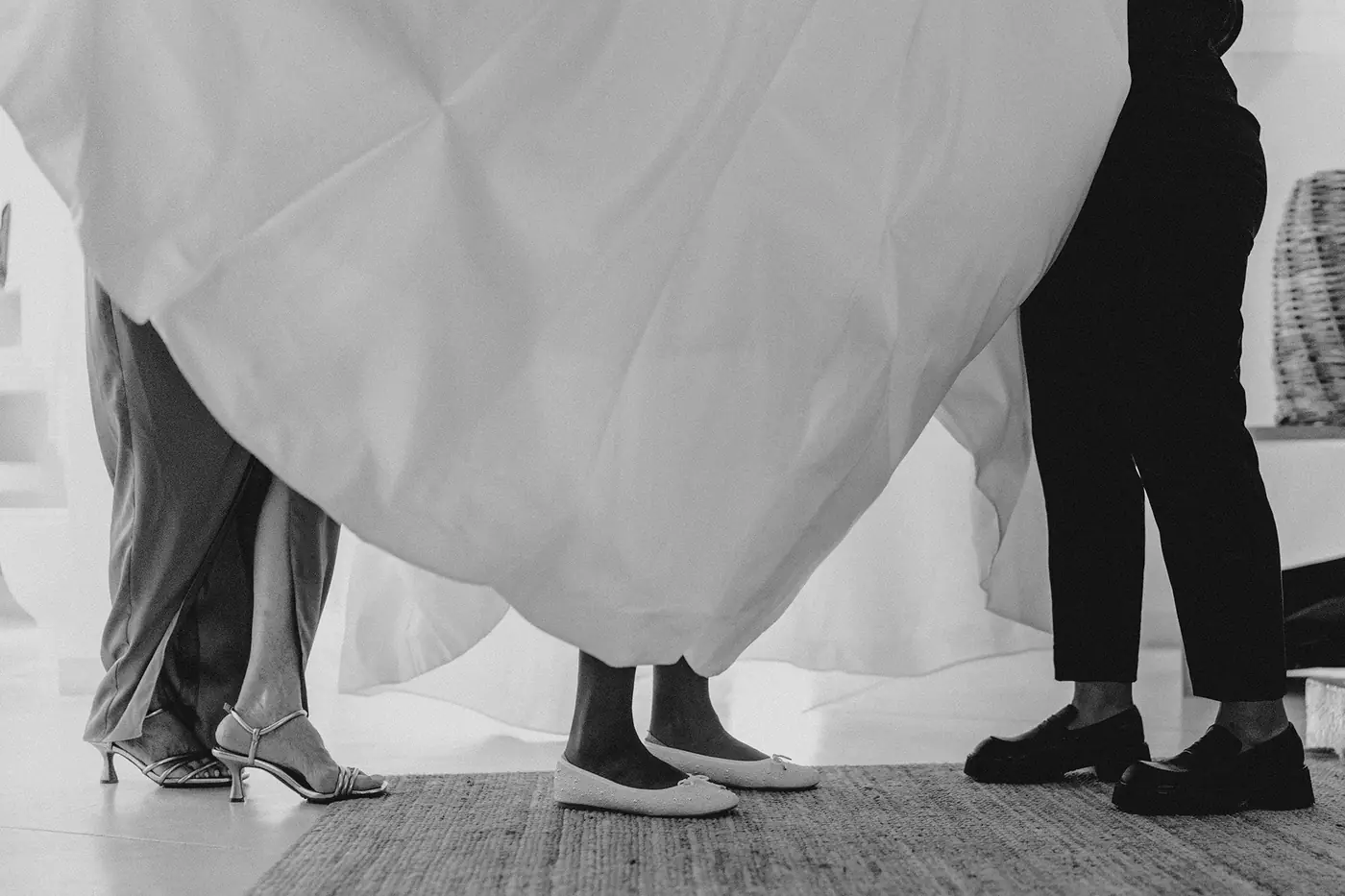 Los zapatos de la novia, de su madre y de otra invitada asoman bajo la falda del vestido