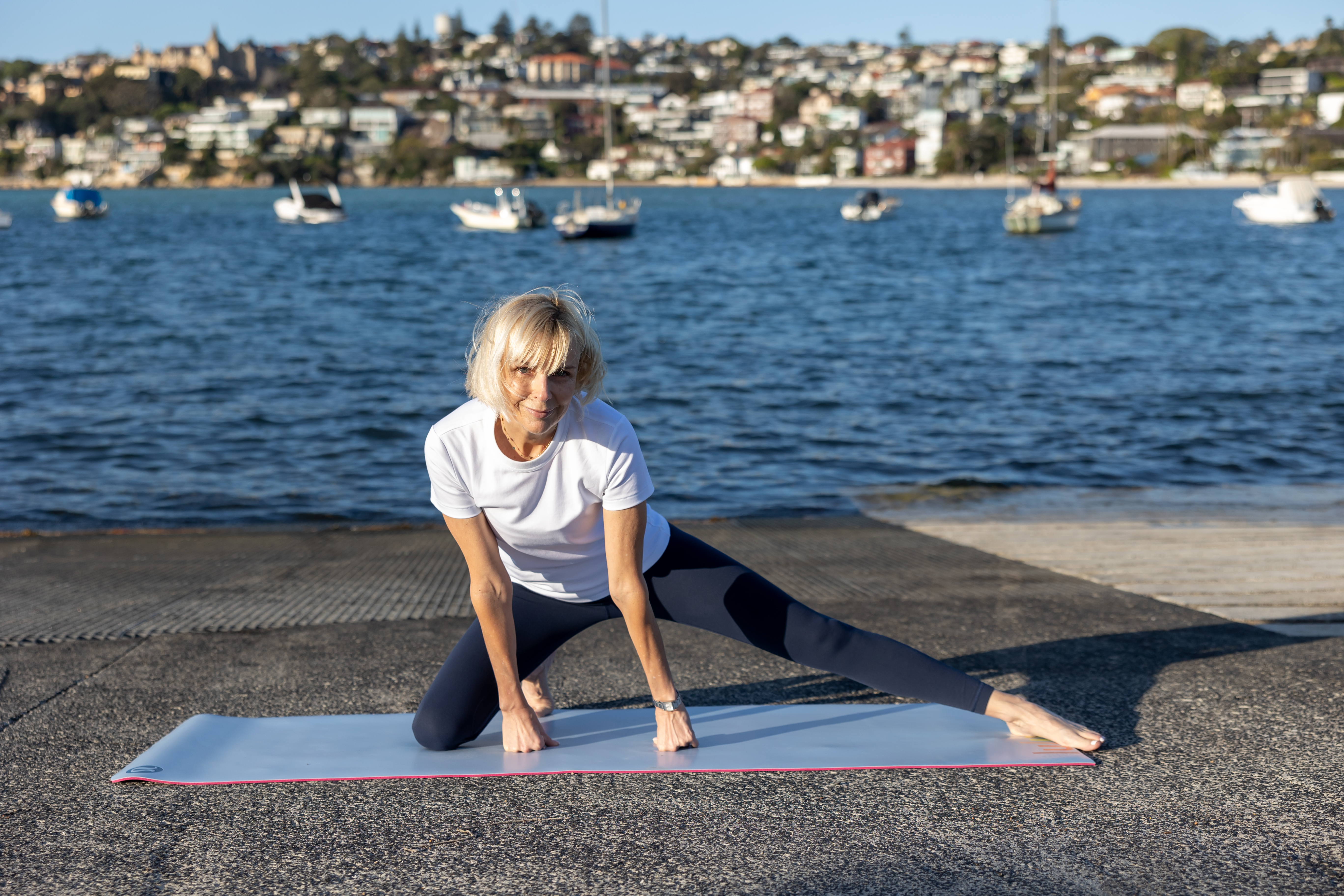 Lisa Lane stretching beside the water