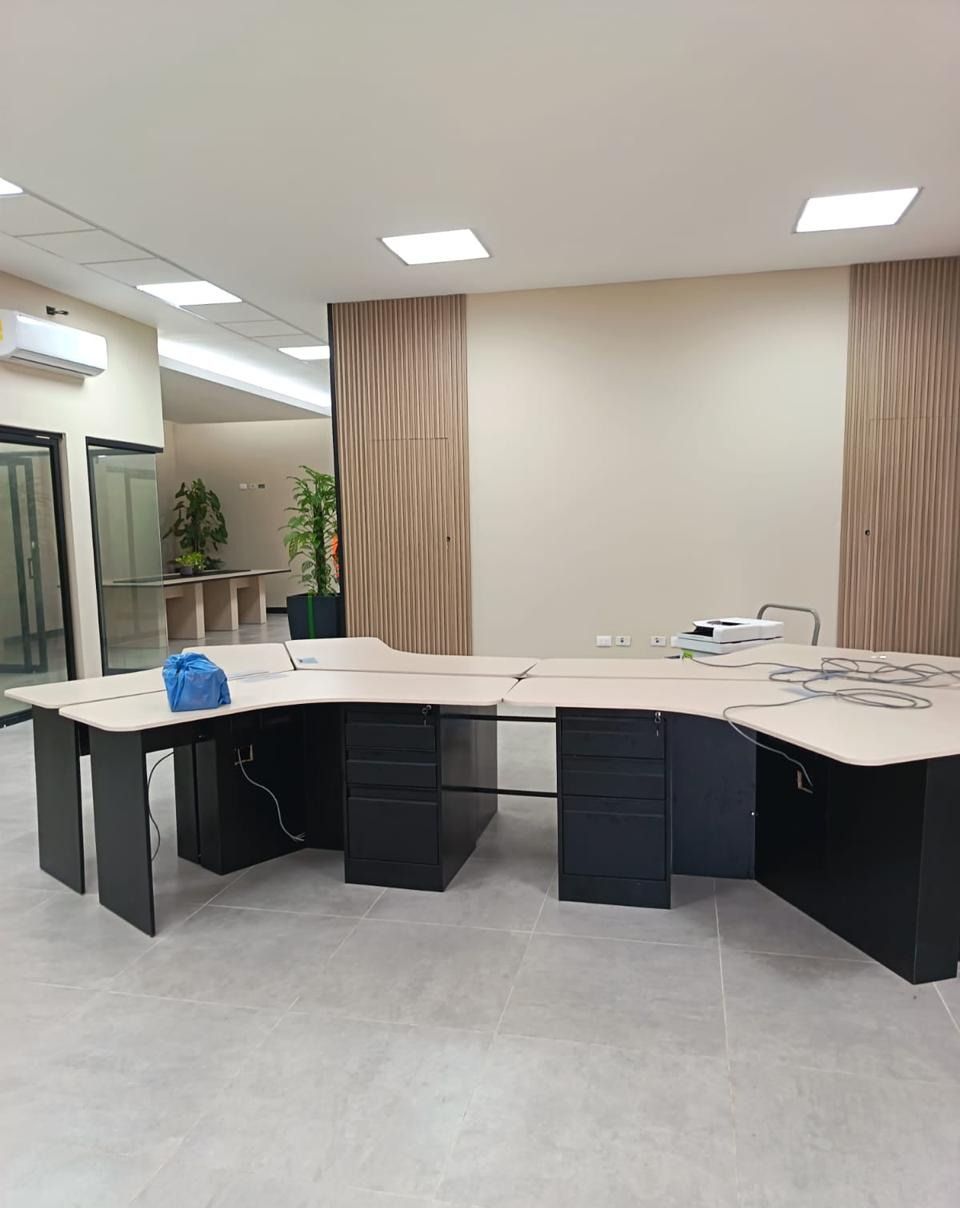 Módulo de escritorios en trébol con paneles de listones de madera y oficinas de vidrio al fondo