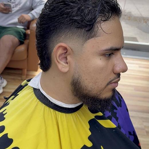 A curly top over a clean mid fade, finished at Will Cut's