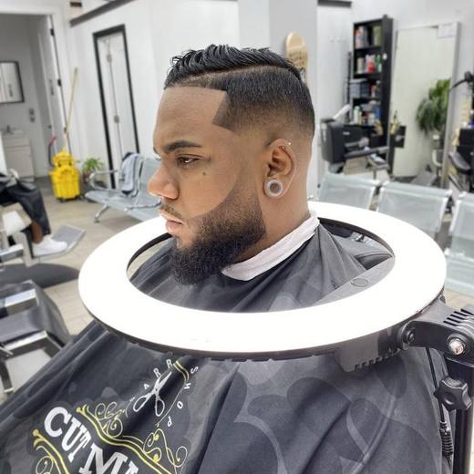 Hard part with a taper fade and a lined-up beard