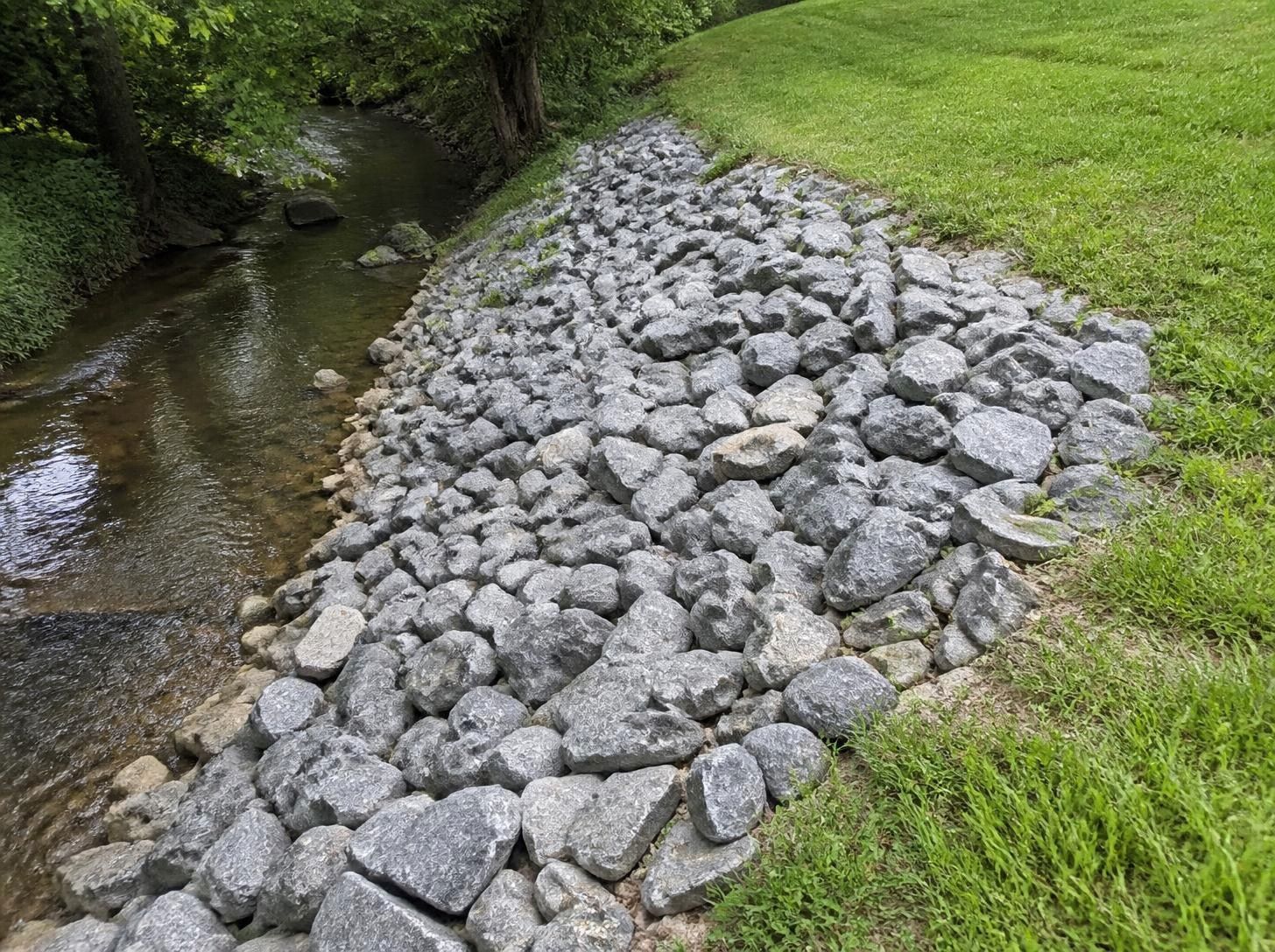 Gray riprap rock lining a grassy slope