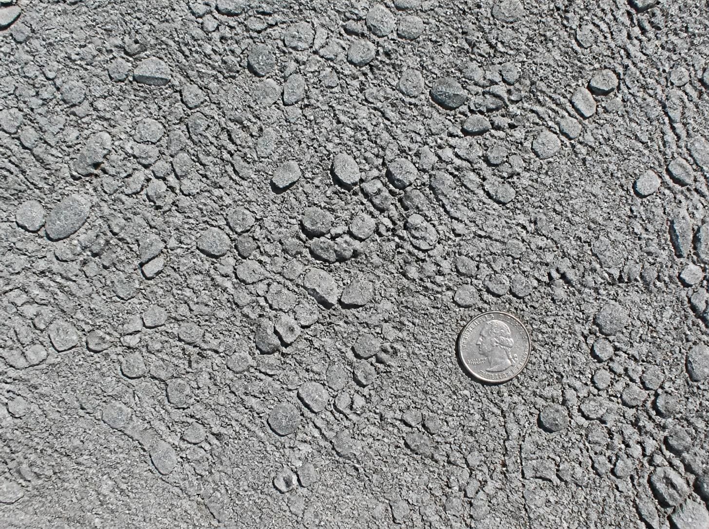 Close-up of #10s limestone screenings, quarter inch down to fines, with a quarter for scale