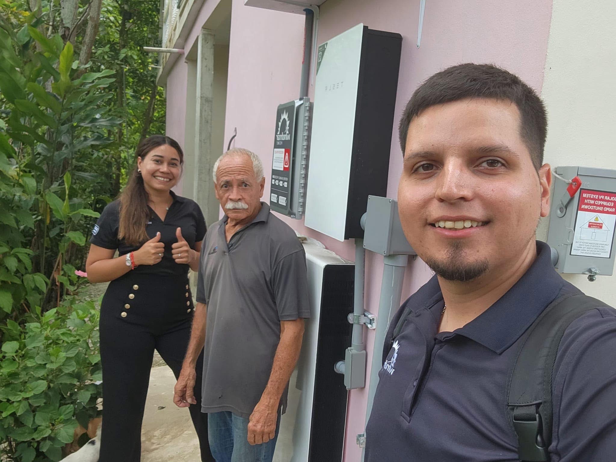 Brian Sanchez con un cliente frente a su instalación solar - WindMar Home Puerto Rico