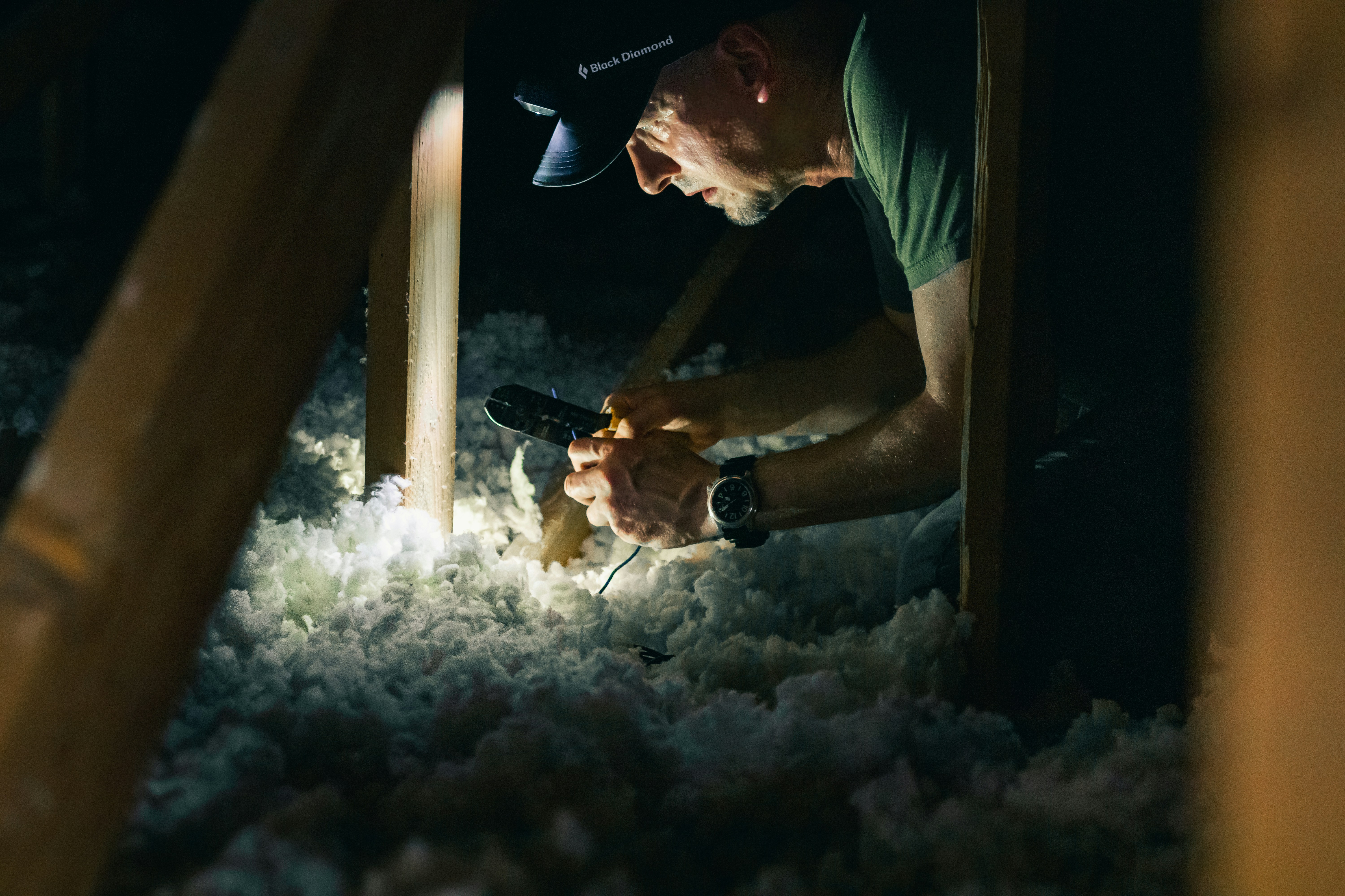 A wildlife removal specialist inspecting the insulation of a Maryland home.
