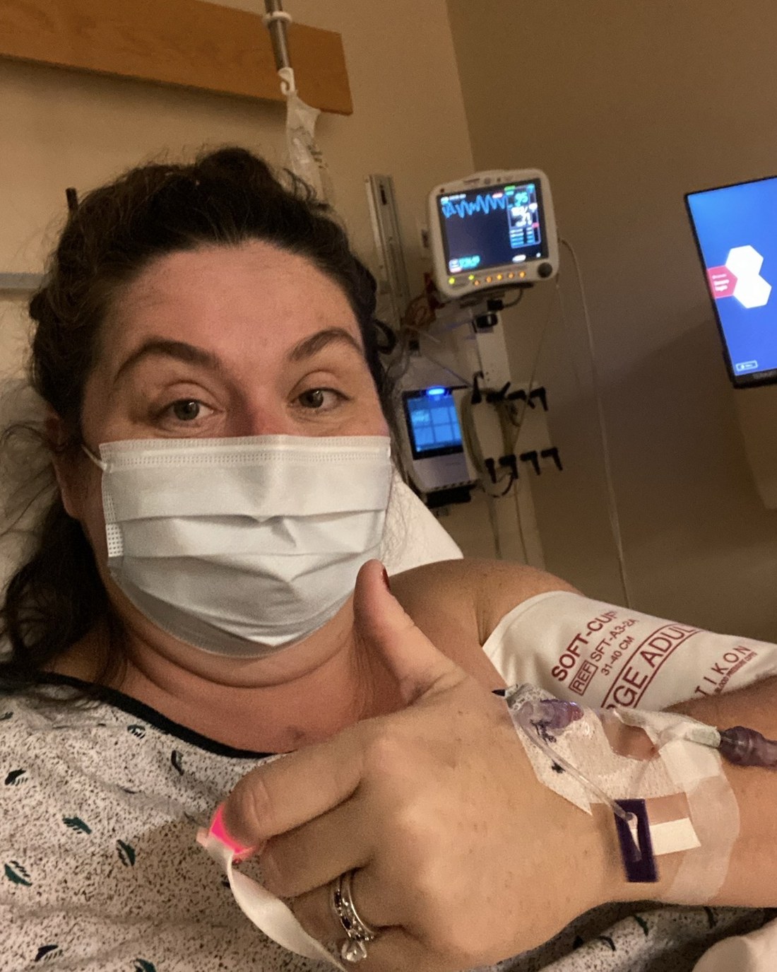 Angela in a hospital gown with an IV line