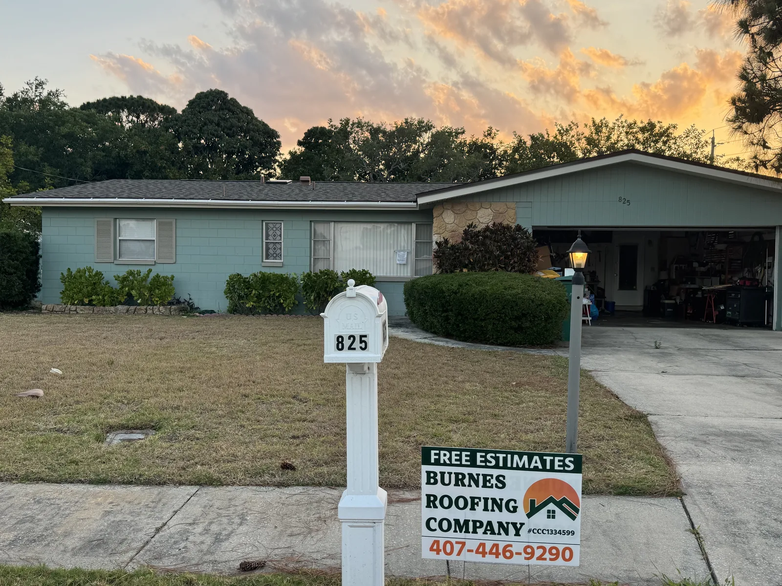 A finished Burnes Roofing job with the company sign in the front yard