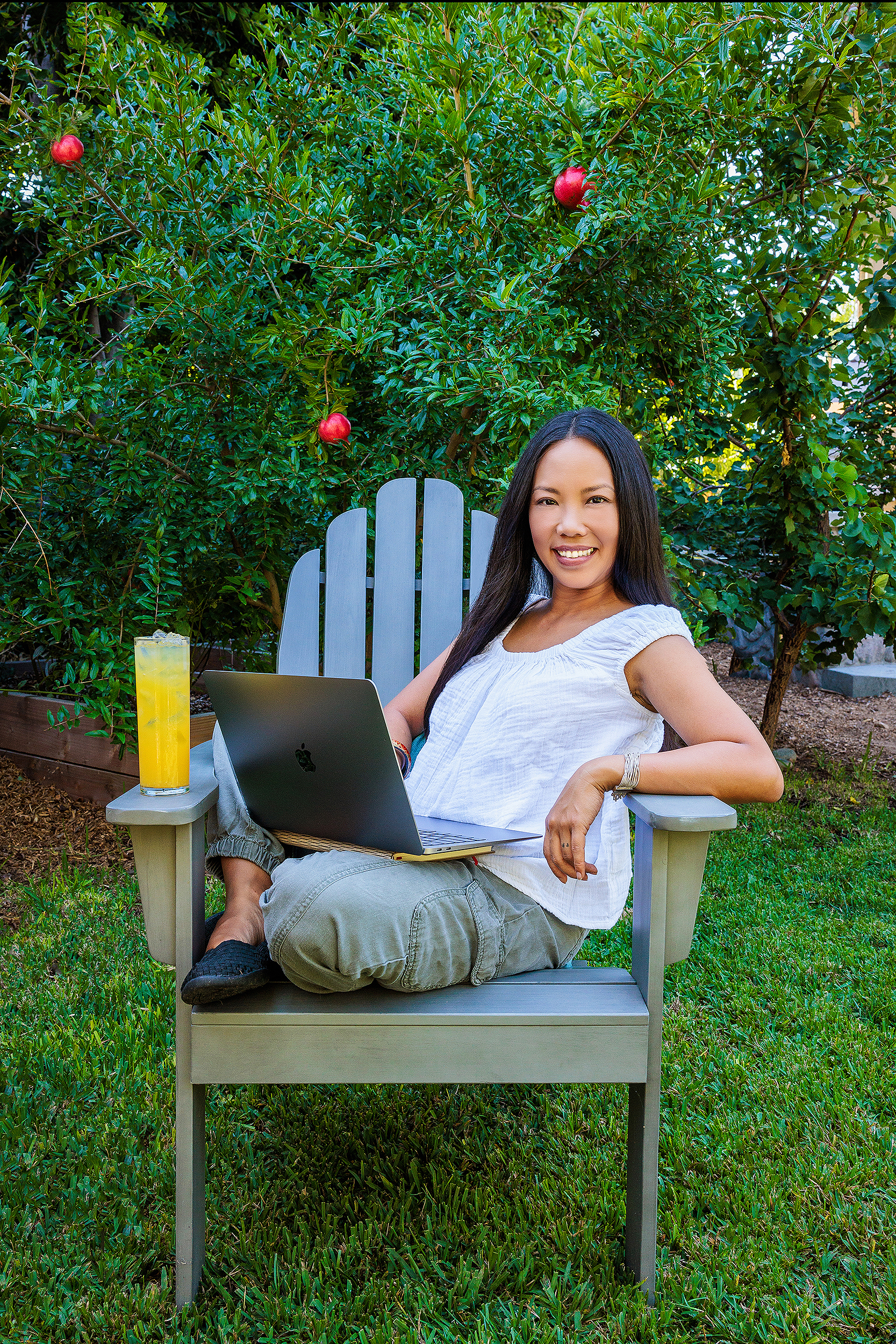 Lifestyle portrait of a female entrepreneur working on a laptop in a garden, photographed by a Los Angeles personal branding photographer for a strategic brand image library.