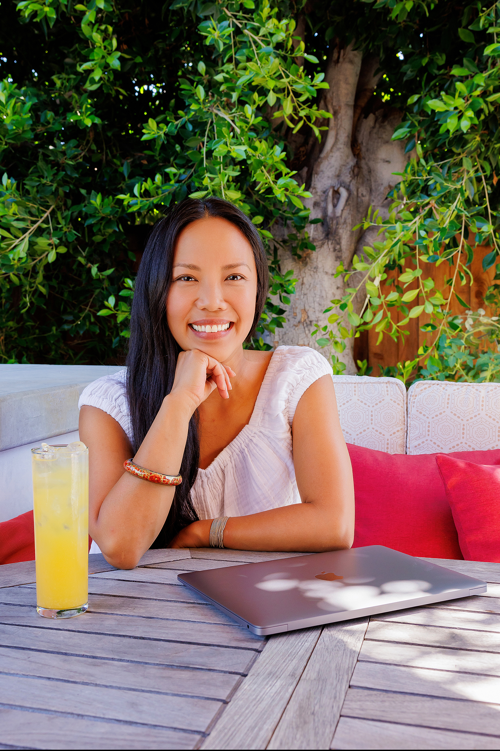 Female business owner working outdoors with a laptop during a personal branding photography session by a Los Angeles branding photographer, creating authentic lifestyle images for business marketing.