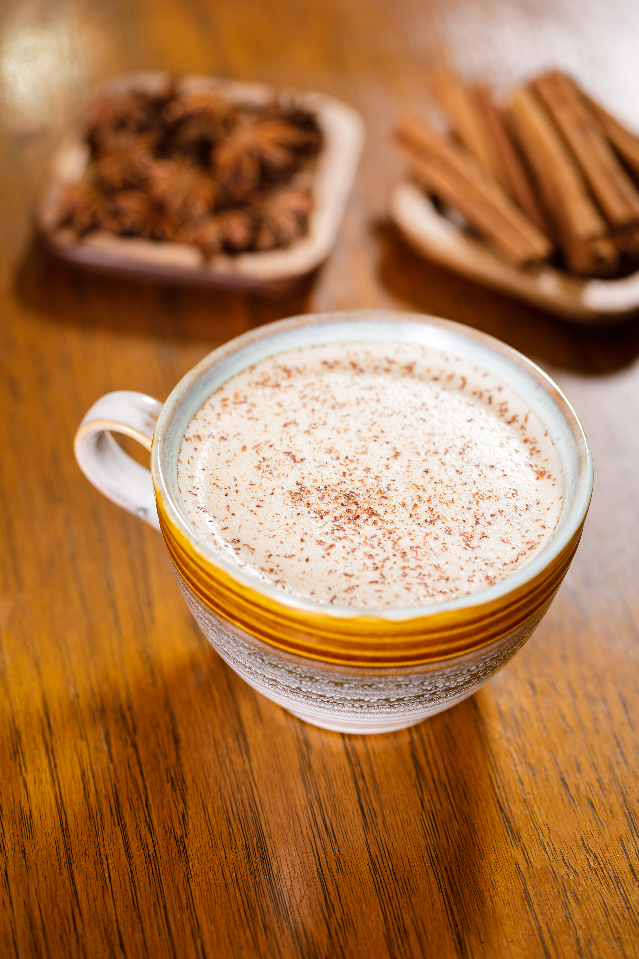 Styled hot beverage photography of a spiced latte on a wooden table, created for café menus, hospitality branding, and food marketing.