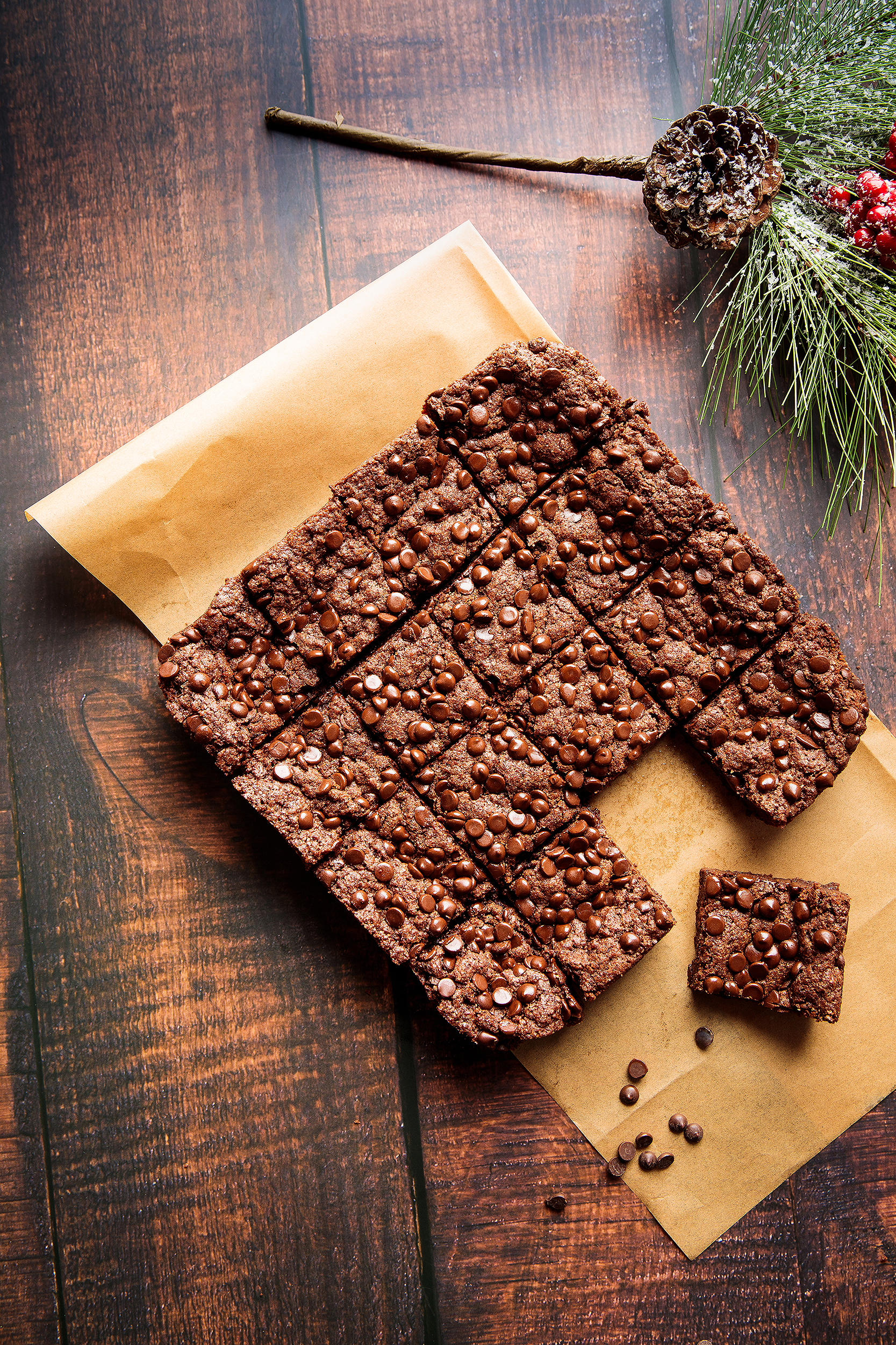 Overhead food photo of vegan chocolate brownies on parchment paper, created for a Christmas cookie cookbook by Los Angeles food photographer Vanessa Stump.