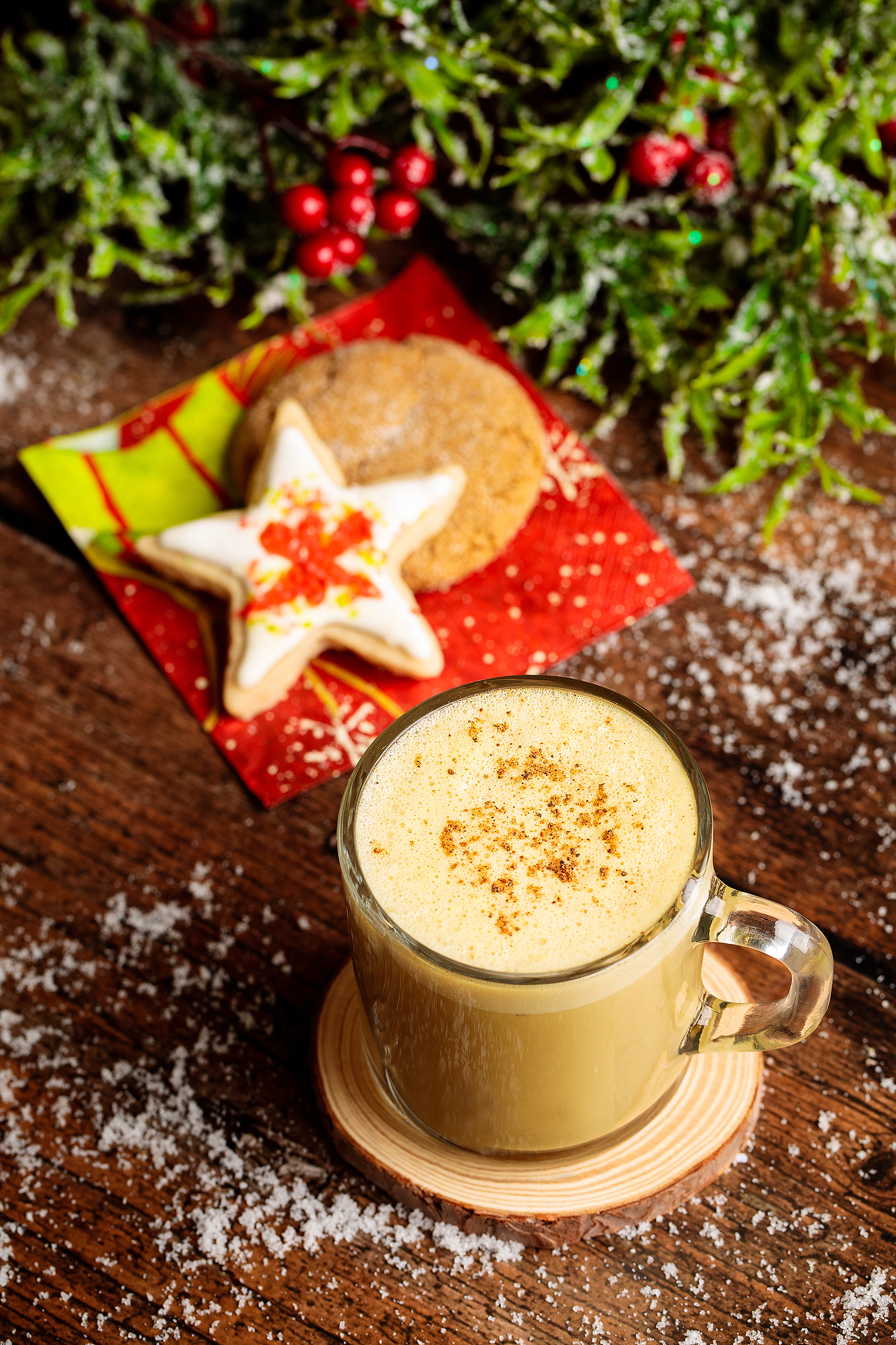 Vegan Christmas latte with decorated holiday cookies and faux snow, styled for a festive holiday cookbook photoshoot.