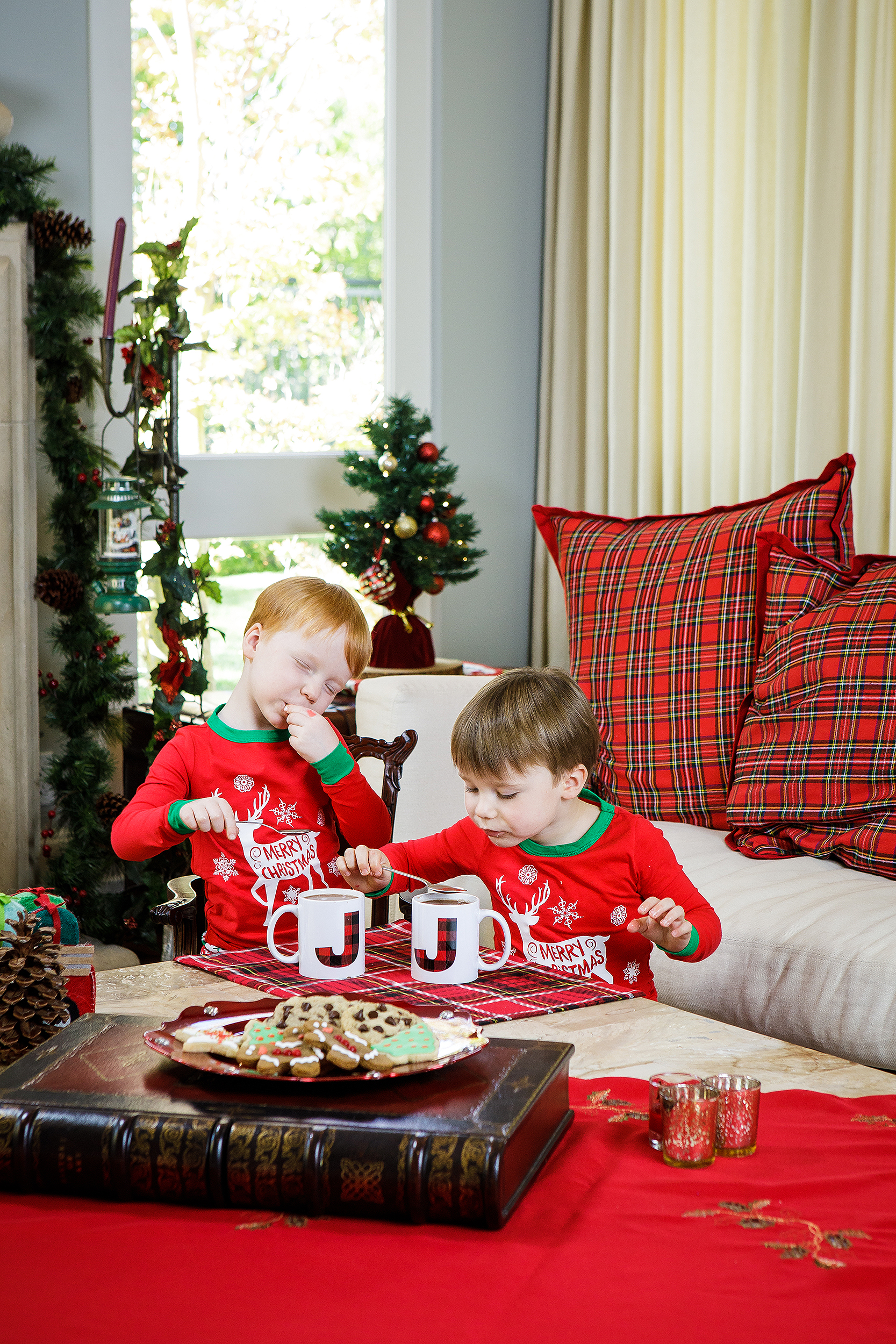 Children in matching Christmas pajamas enjoying vegan holiday cookies and cocoa, photographed for a festive vegan cookie cookbook.