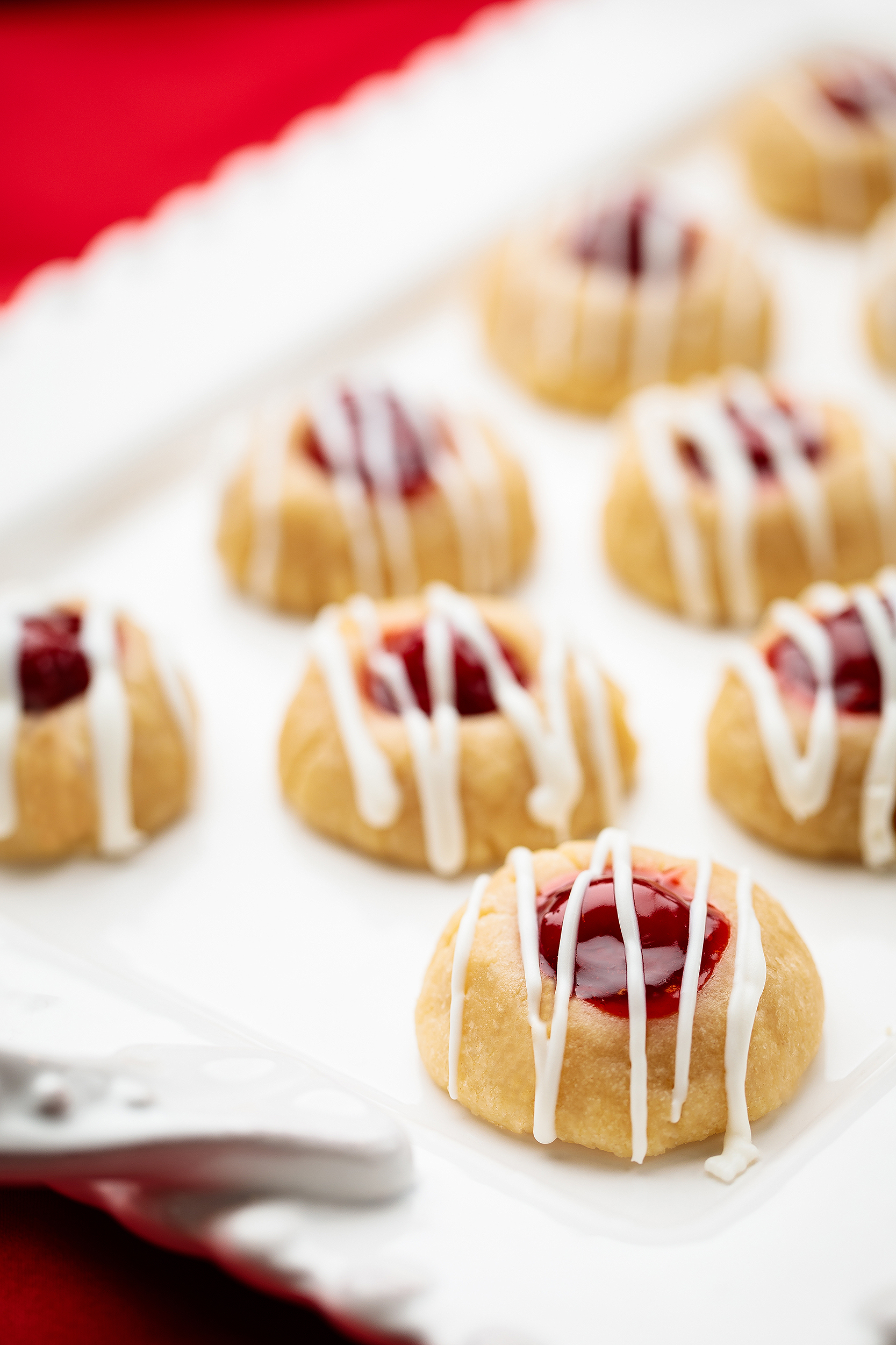 Vegan thumbprint cookies filled with berry jam and drizzled icing, created for a Christmas cookies and cocoa cookbook.