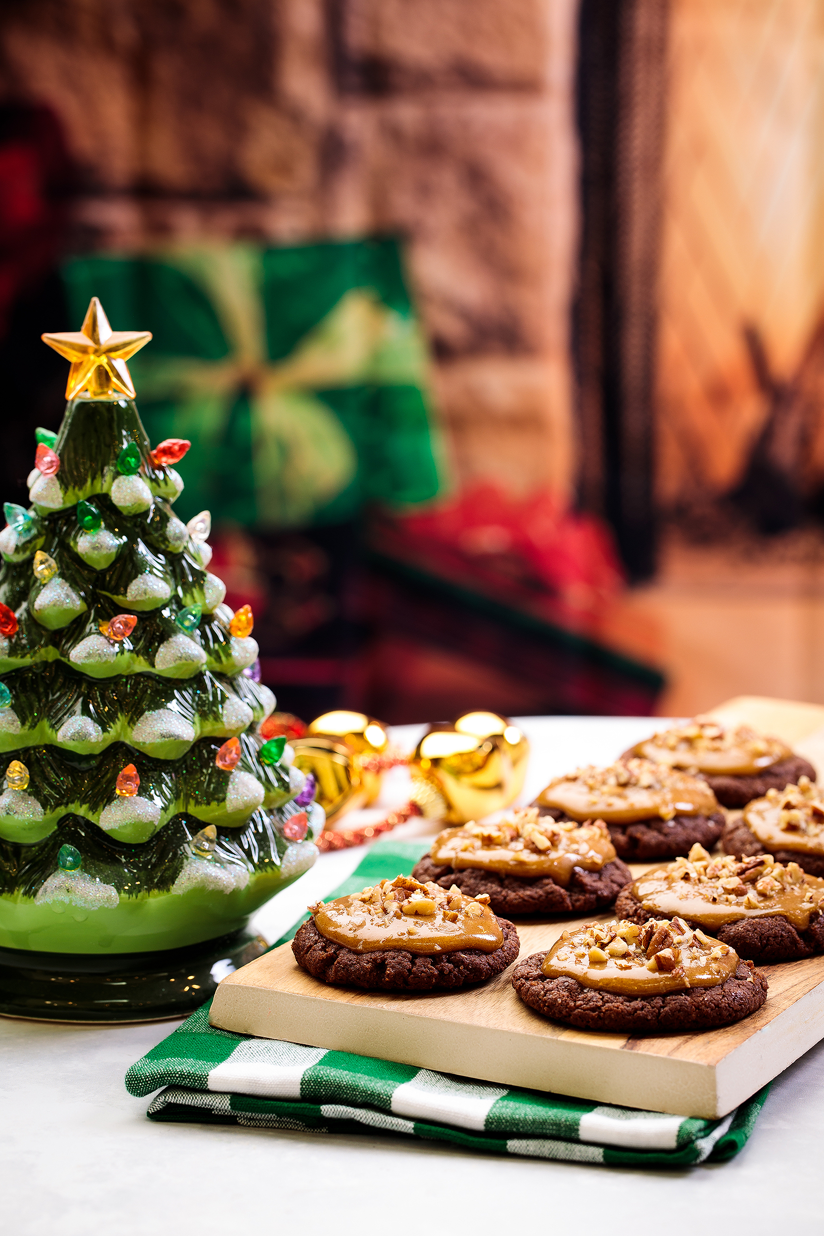 Plate of vegan Christmas cookies styled beside a ceramic Christmas tree, photographed for a holiday cookie cookbook.