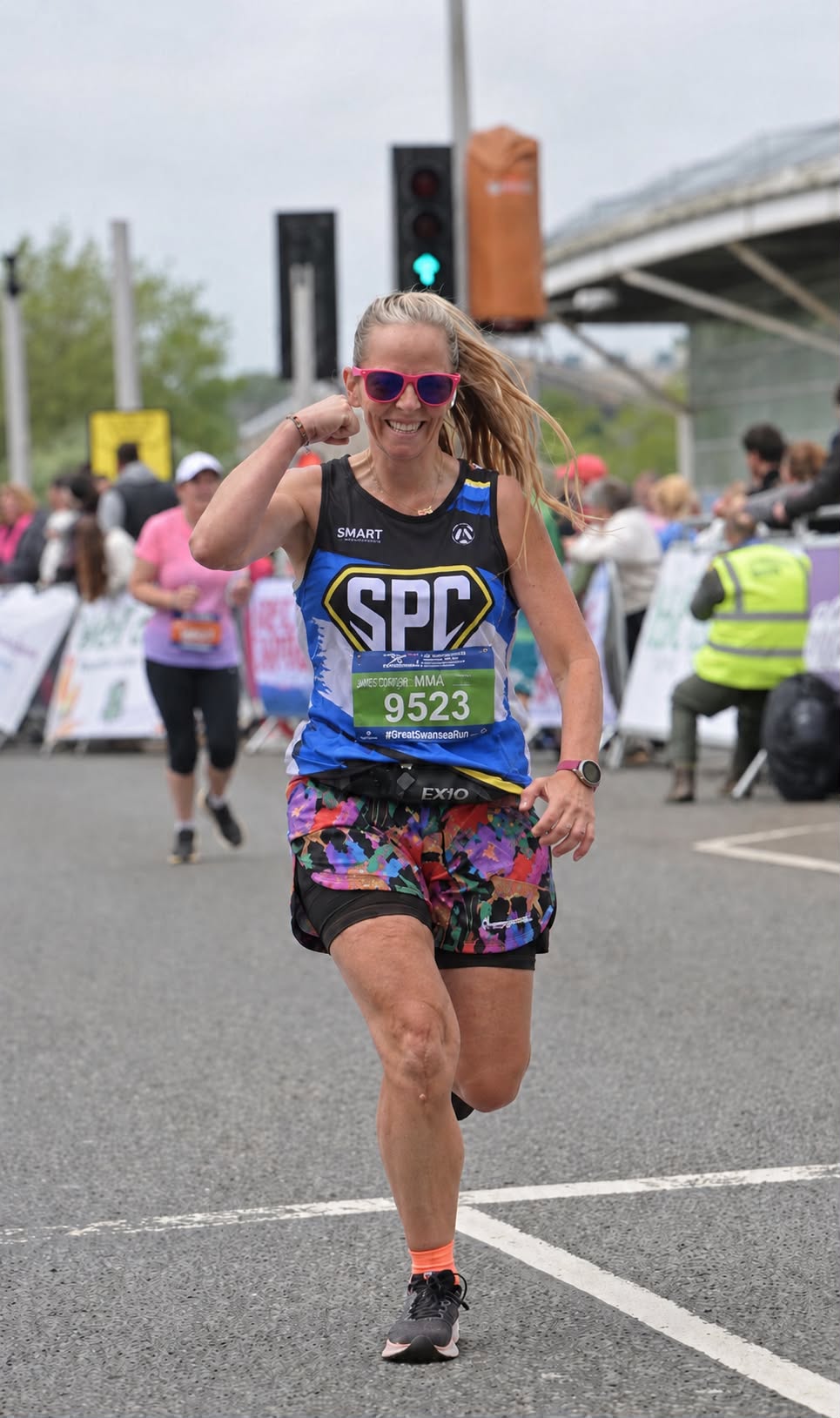 Andrea, a Smart Performance Coaching athlete, running in an SPC race vest