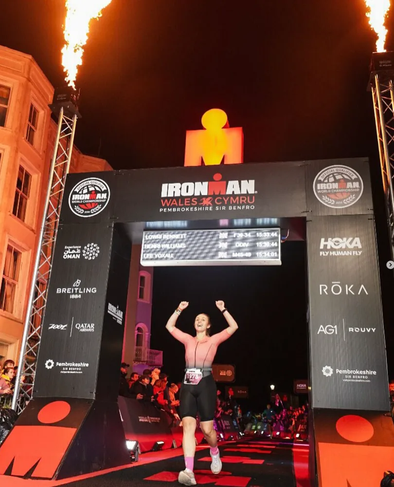 Lowri with her arms raised, finishing Ironman Wales