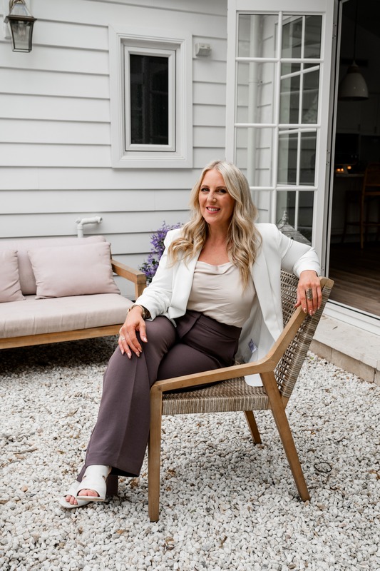 Kellie Gilbey, Founder of Her Soul Travels, seated outdoors