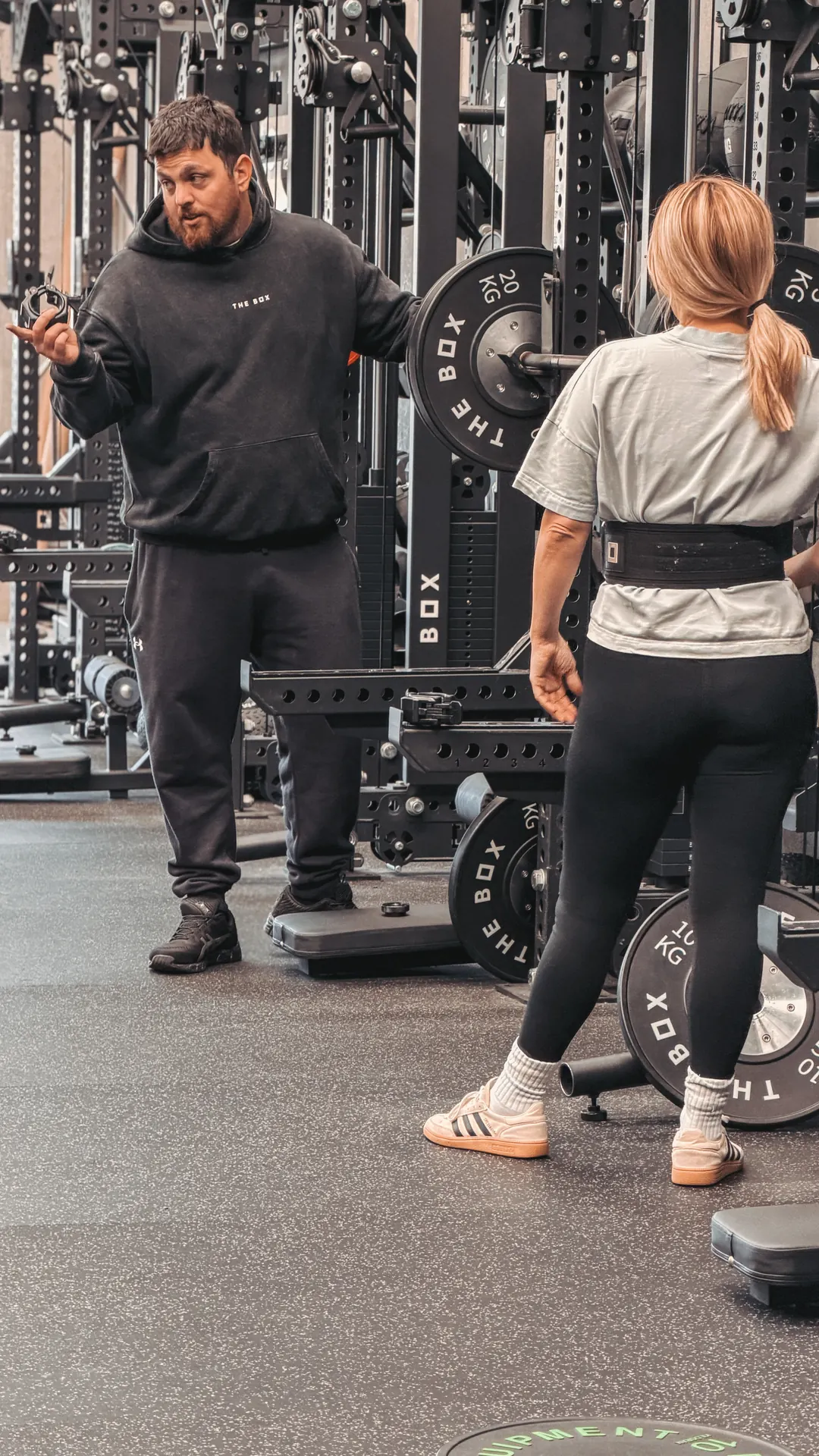 Coach explaining technique at the squat rack