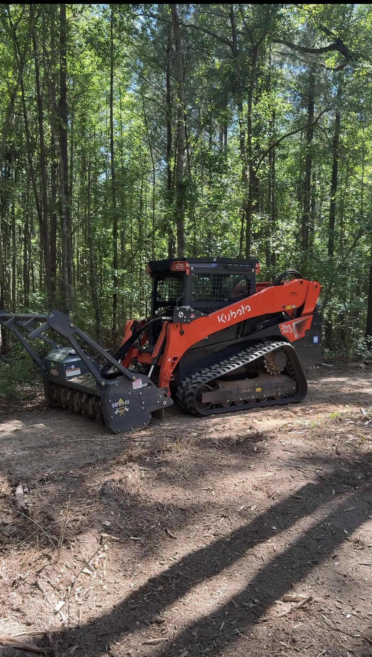 The Kubota SVL97-3 and mulching head working in a stand of hardwood timber