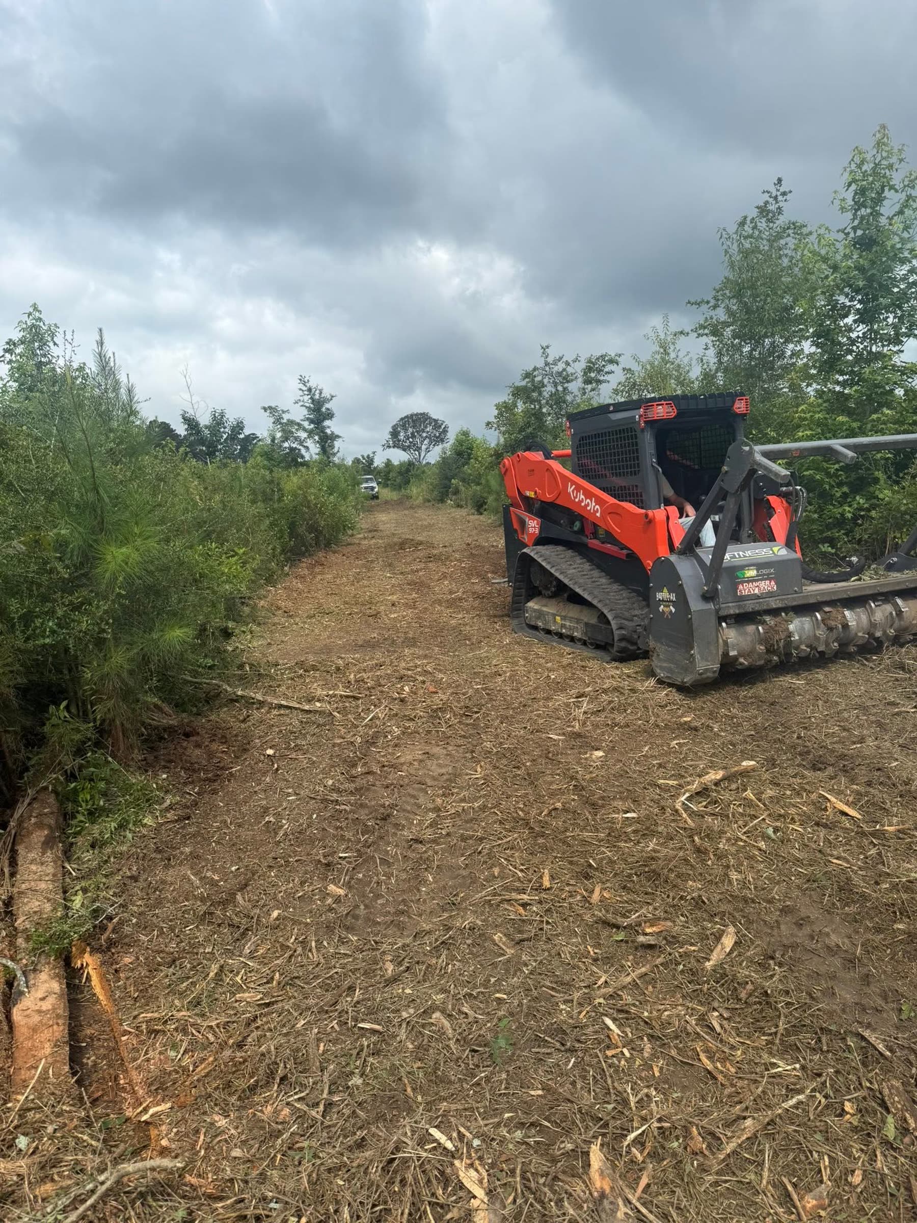 The SVL97-3 on its rubber tracks partway down a lane it has just mulched
