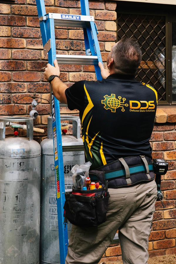 Security camera installation on eave of house by DDS technician