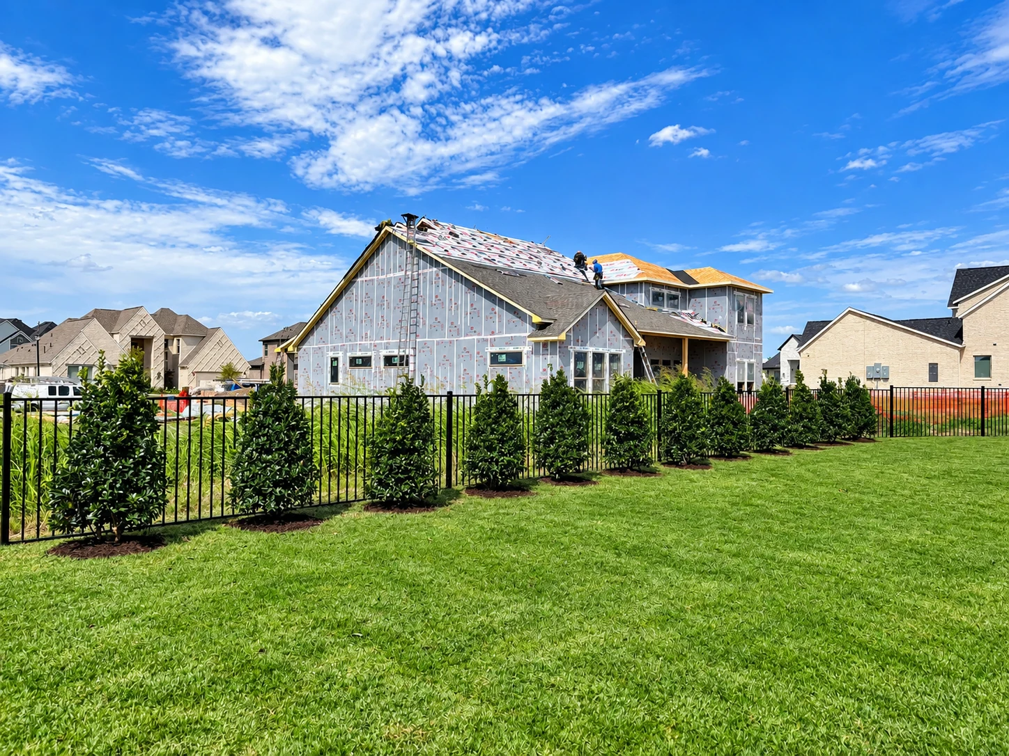 Curved stone masonry border with ornamental evergreens and fresh mulch detailing.
