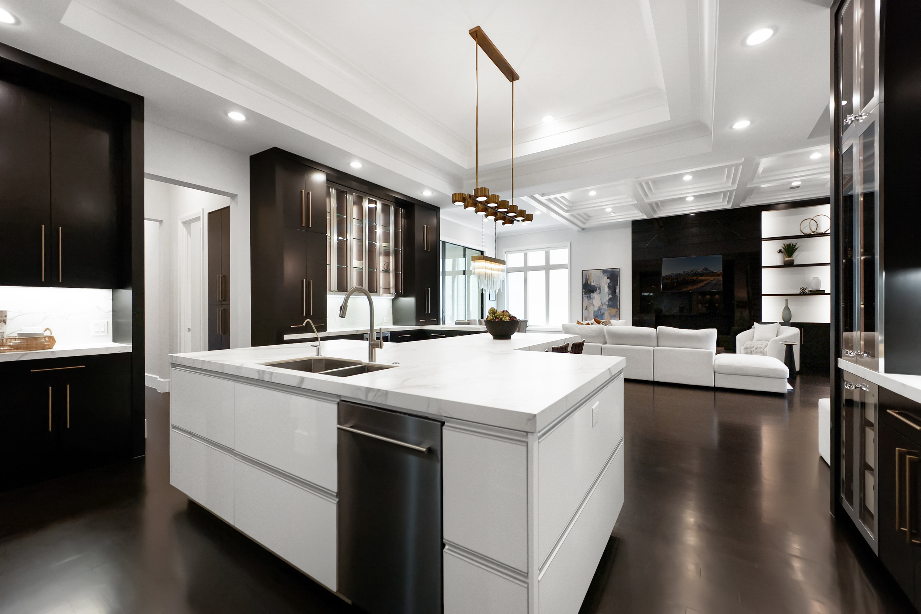 Large kitchen with dark cabinets and white counters with minimal decorations Large kitchen with dark cabinets and white counters with minimal decorations
