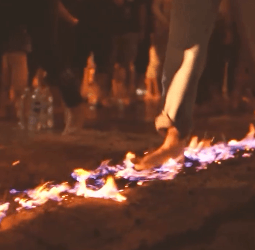 Detalle de un participante caminando sobre las brasas en la Feria EFFIX