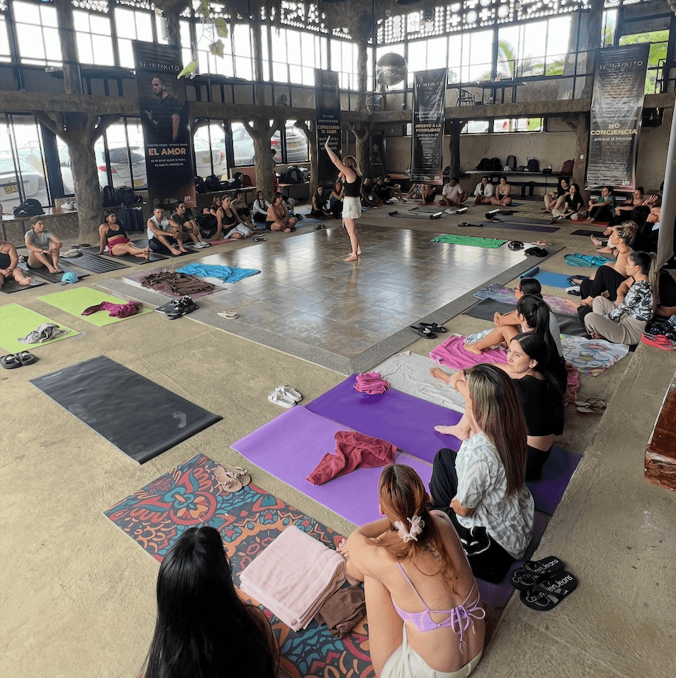 Gemma Ventaja facilitando una dinámica grupal con participantes sentados en esterillas