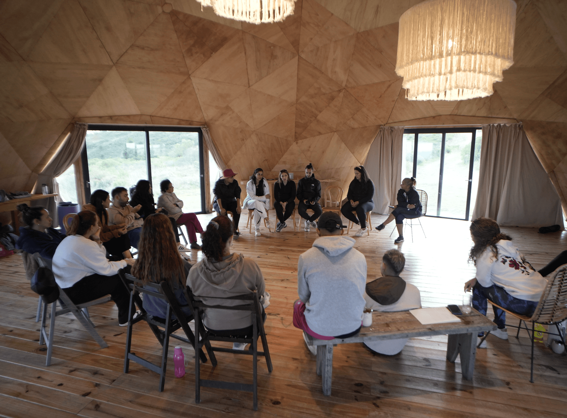 Círculo de comunidad reunido dentro de una cúpula de madera