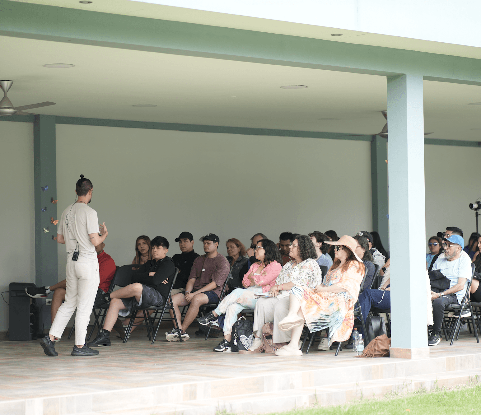 Israel Moreno facilitando una dinámica al aire libre con el grupo sentado