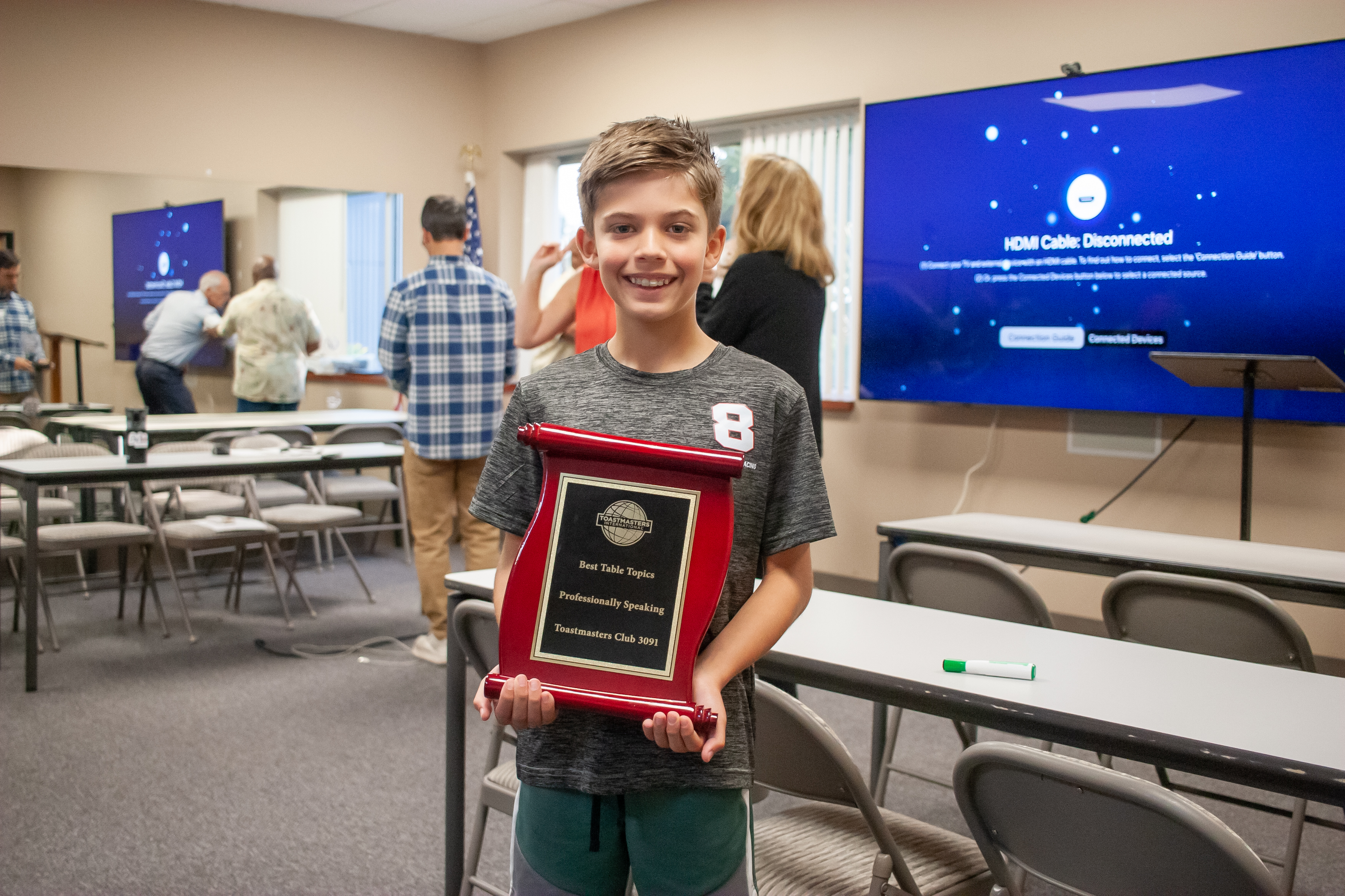 Caleb holding an award at a speaking event