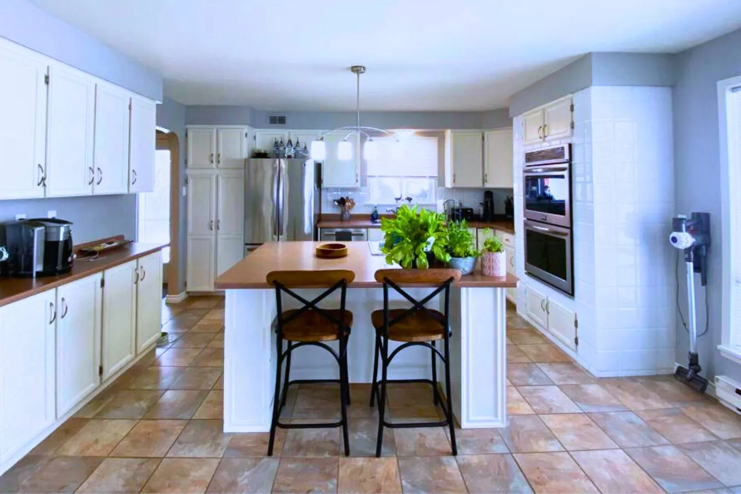 Bayside kitchen with white cabinets and an island with stools