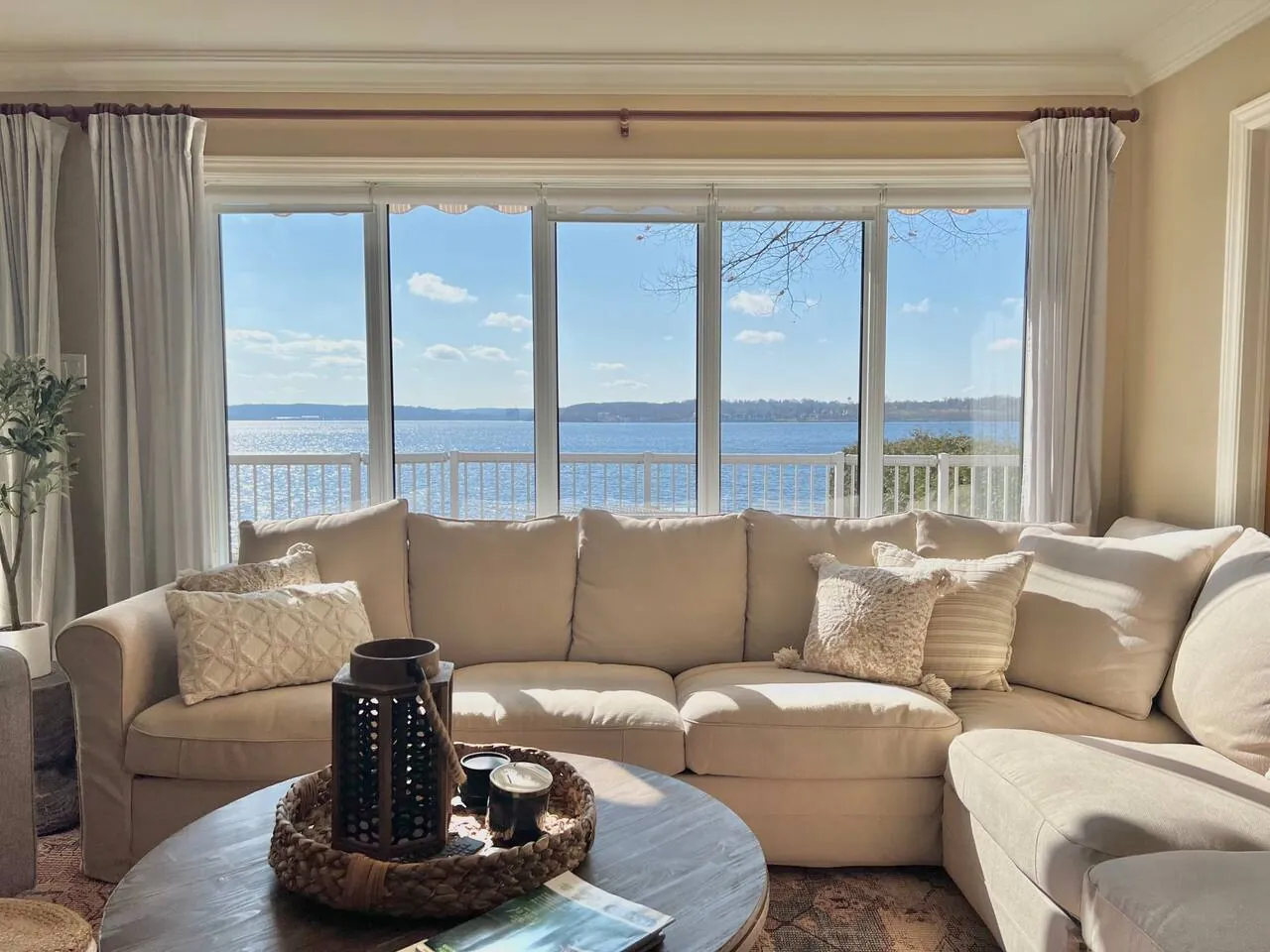 Bayside living room with a cream sectional facing a wide picture window over Georgian Bay