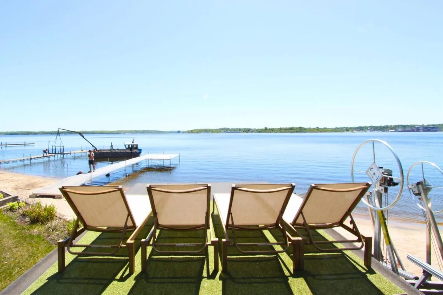 Loungers on the Bayside boathouse rooftop facing the dock and the bay