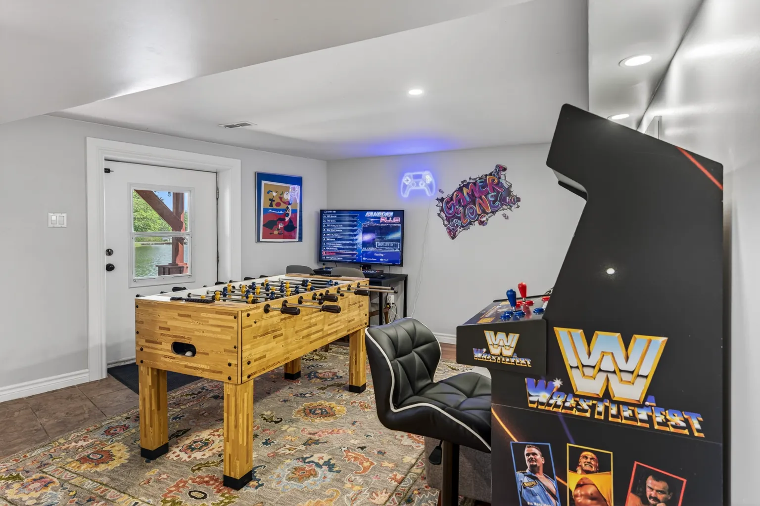 Games room at Good Times with a foosball table, arcade machine and gaming chair