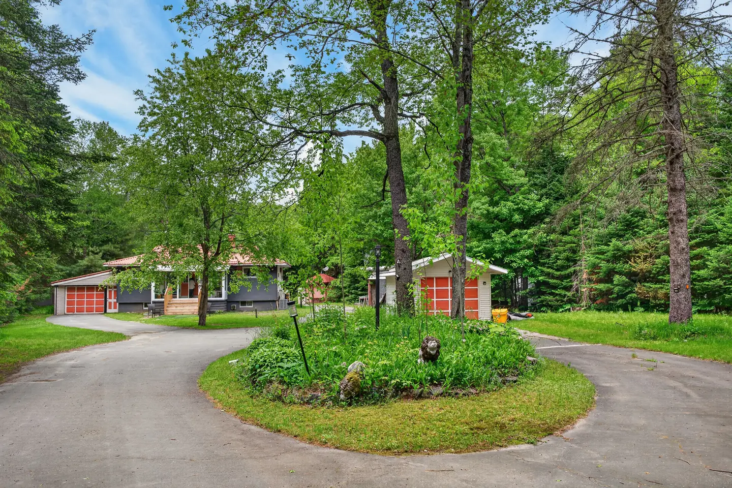 Circular drive with a garden island in front of The Mara and its red garage doors