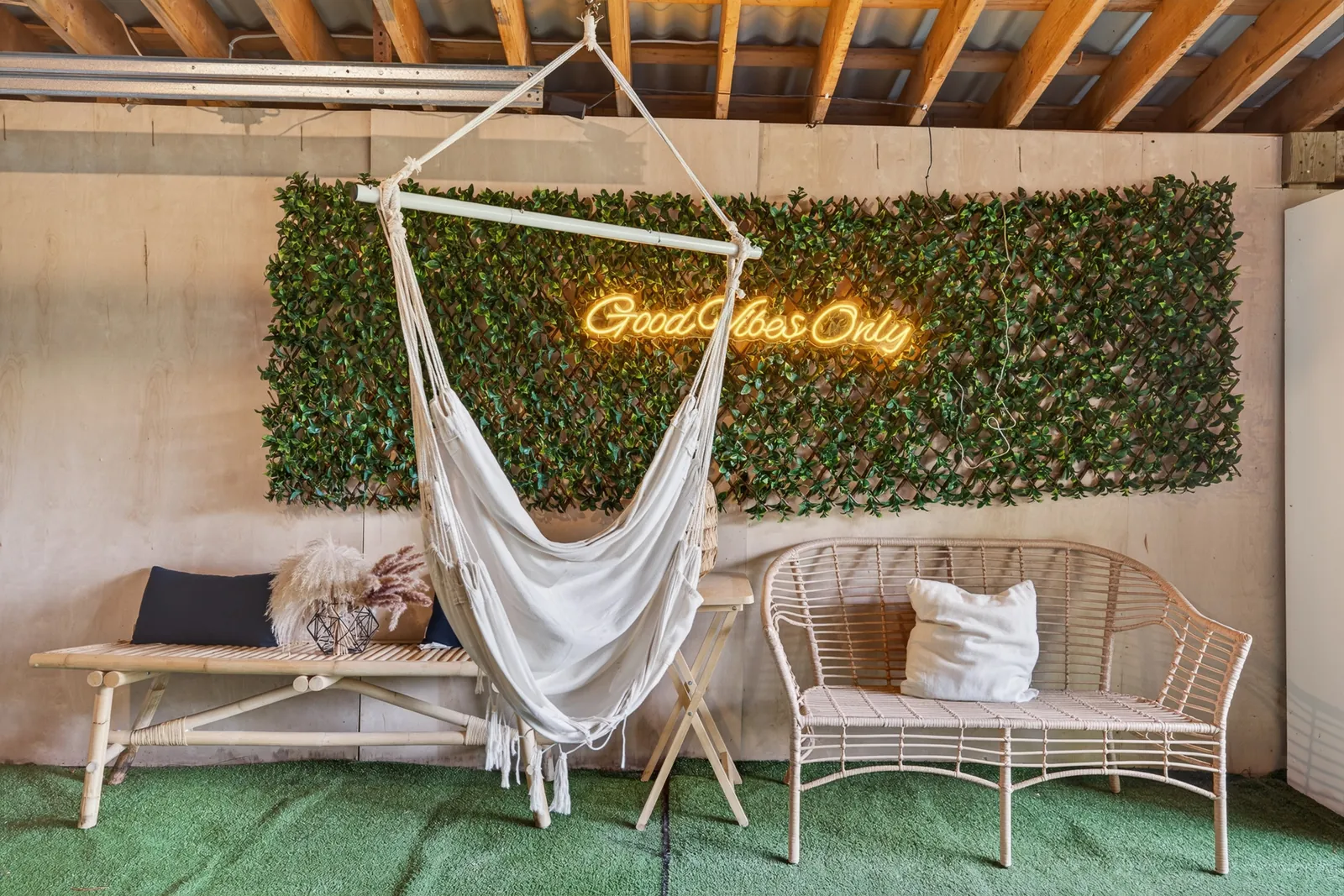 Hanging hammock chair and lounge seating in front of a living green wall at The Mara