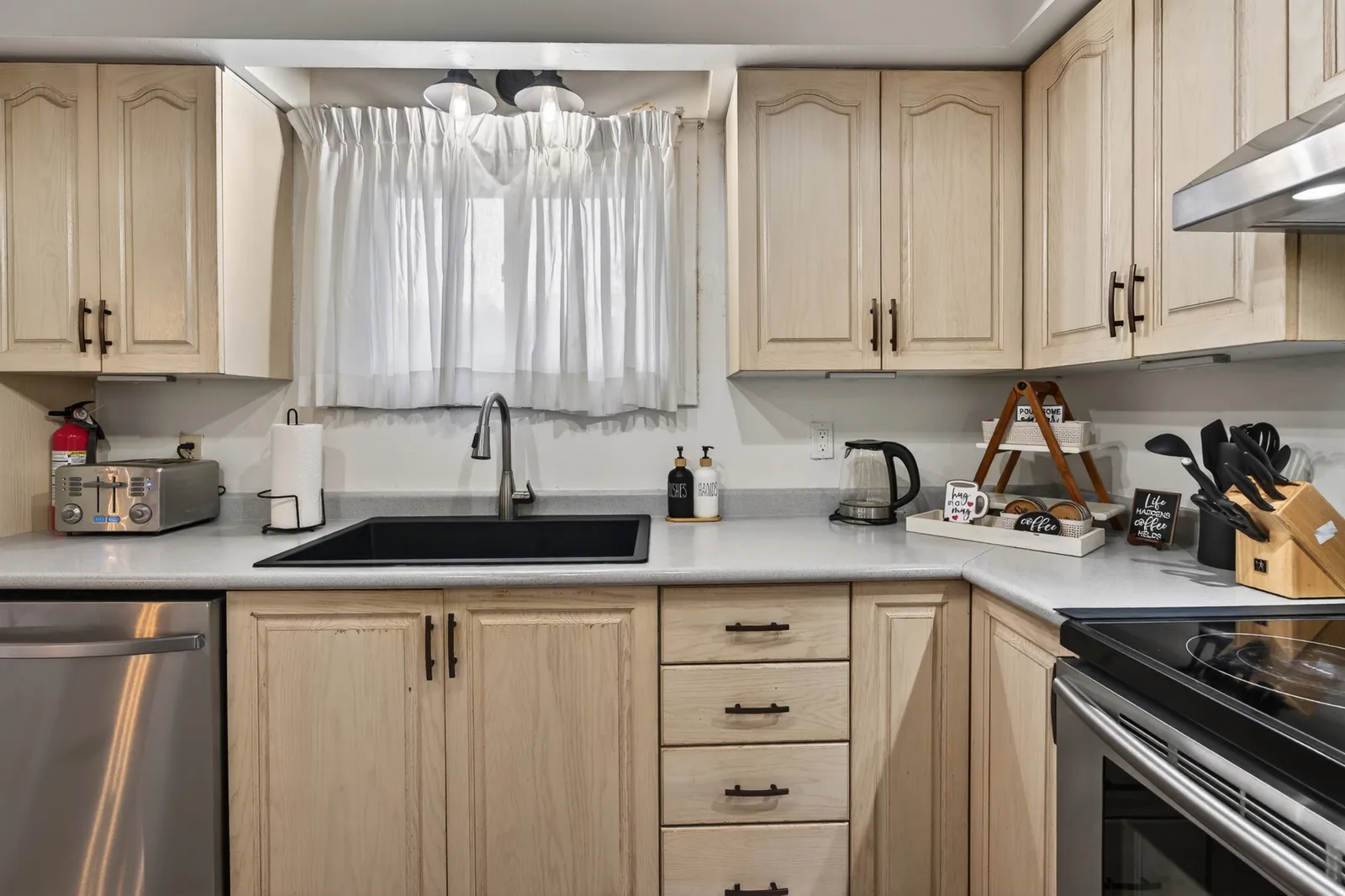 Updated kitchen at The Mara with light cabinets, stainless appliances and a window over the sink