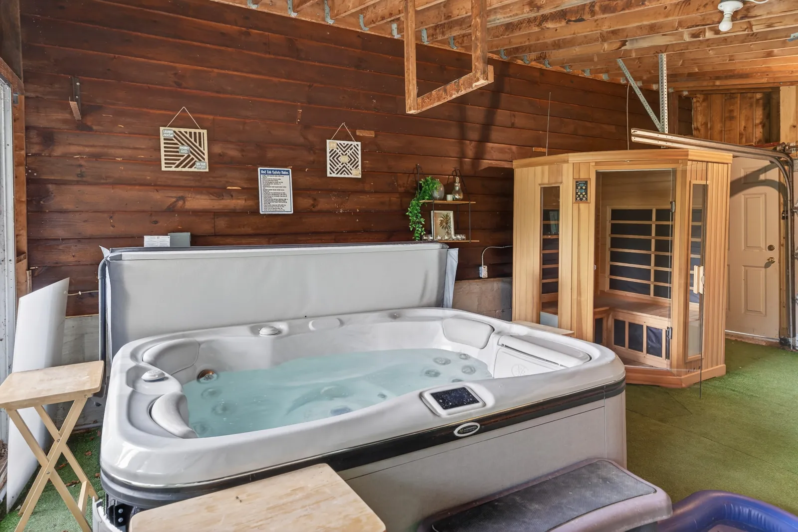 Hot tub and sauna cabin in The Mara wellness room under a timber ceiling