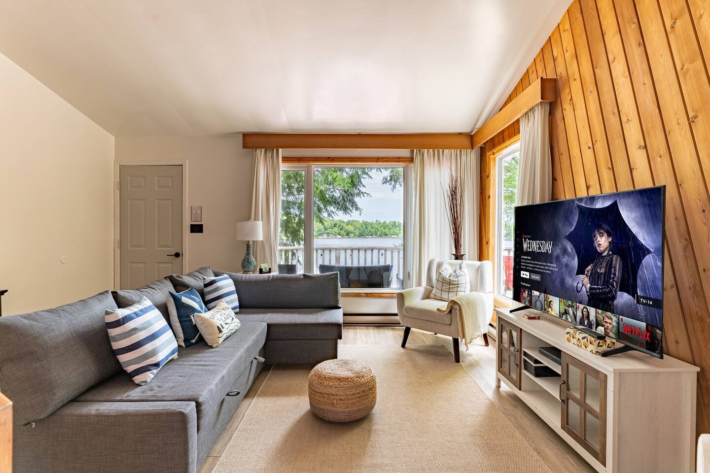 Open-plan living room with large windows onto the lake