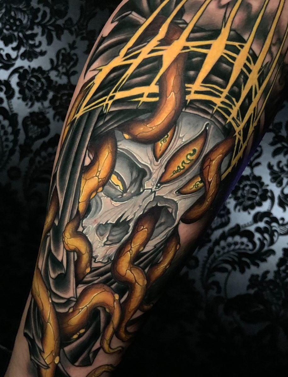 Hooded skull with gold tendrils tattoo