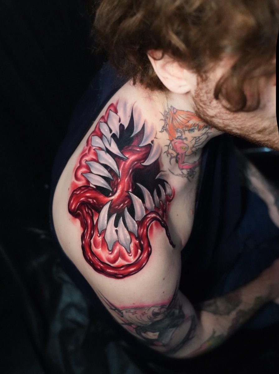 Red maw on shoulder tattoo