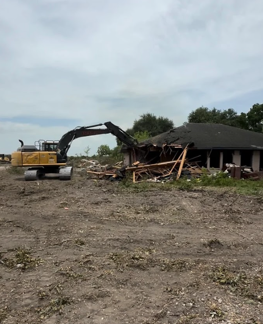 Demolition equipment removing structures and clearing debris